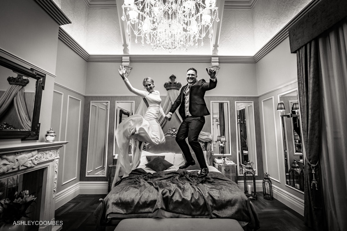 bride and groom bouncing on bed